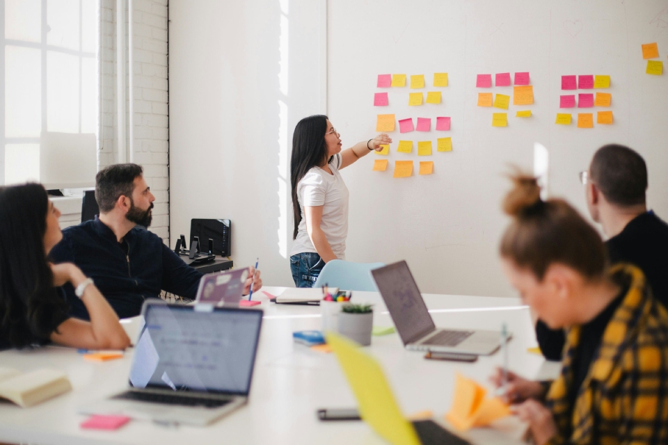 Group working with sticky notes on wall.